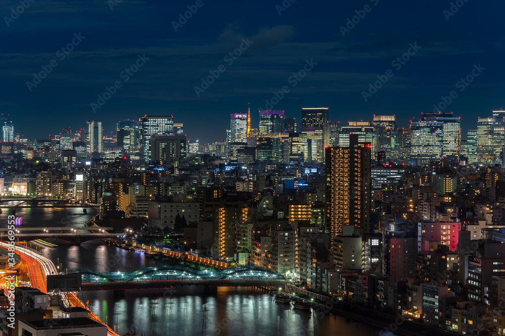 Aerial night panoramic view of the Sumida river bridges and higways light-up with the skyscrapers of Tokyo.