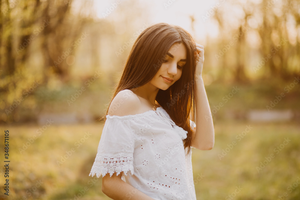 Young girl in wheat field at sunset. Portrait of a beauty adult woman posing looking at camera in a park. Young girl in wheat field at sunset. Portrait of a beauty adult woman posing looking at camera in a park.