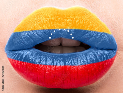 Female lips close up with a picture flag of Venesuela. Blue, Yellow, red. photo