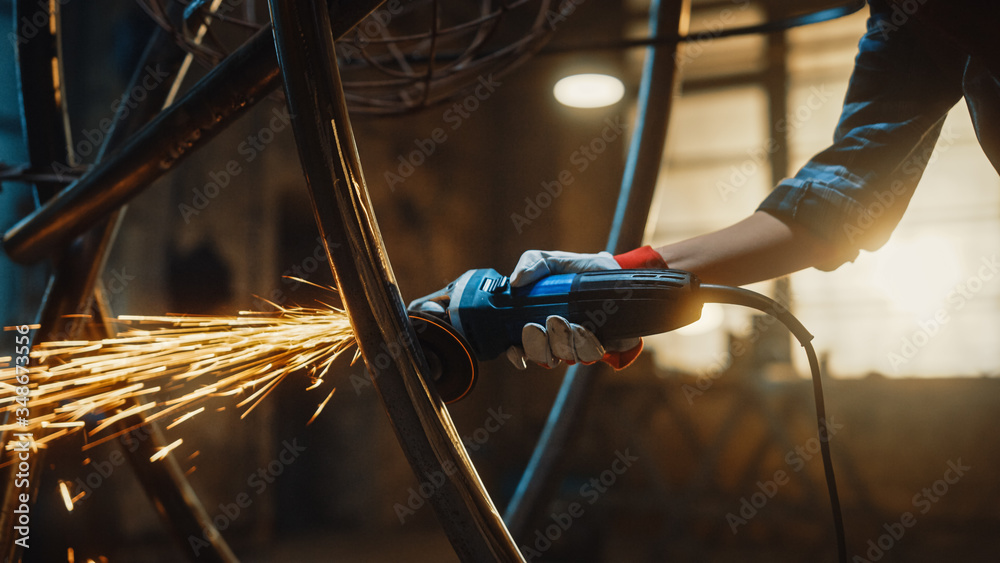 Close Up of Hands of a Metal Fabricator Wearing Safety Gloves and Grinding  a Steel Tube