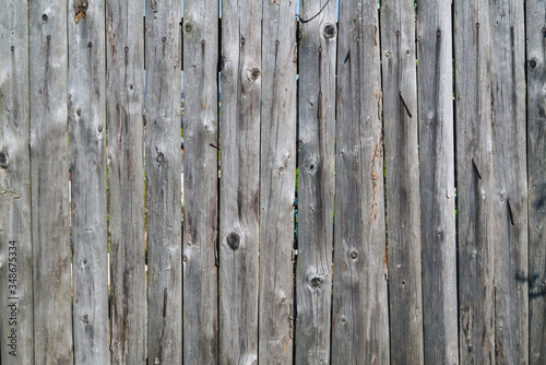 The texture of the boards of an old wooden fence closeup. Old wooden planks background.