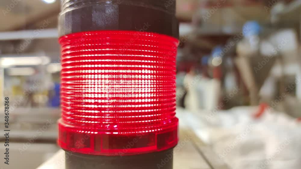 Close-up of red warning light blinking with industrial background, 4k 30 fps
