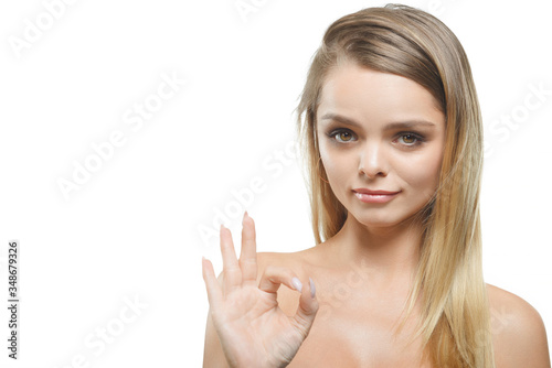 The girl shows the gesture everything is fine on a white background.