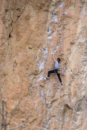 Young woman climbing a rock