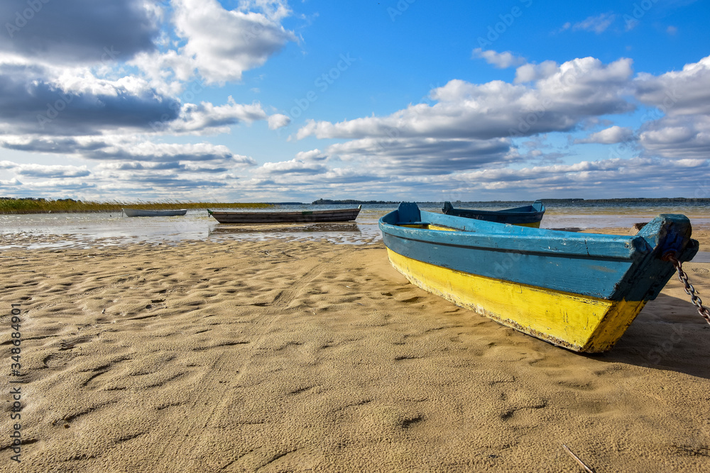 Wooden fising boats on the drying lake bed. Natural disaster, Blue sky background. Wooden fising boats on the drying lake bed. Natural disaster, Blue sky background.