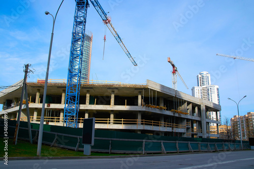 construction of a large building with construction cranes in the city