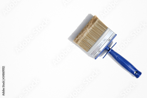 Decorator brush isolated on white background. Wide paintbrush usually used for painting walls, furniture and steel surfaces. Masonry brush with plastic handle and long bristles.
