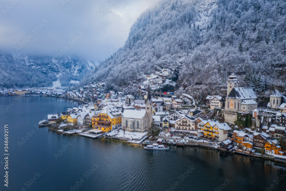 Image of cold and snowy winter in Austria. Beautiful mountain and nature at Hallstatt near Obertraun city opposite the Hallstatter See lake at foggy weather. January 2020