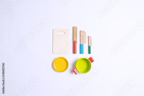 Sets of wooden knife toys, chopping board and sets of pots on top of white background