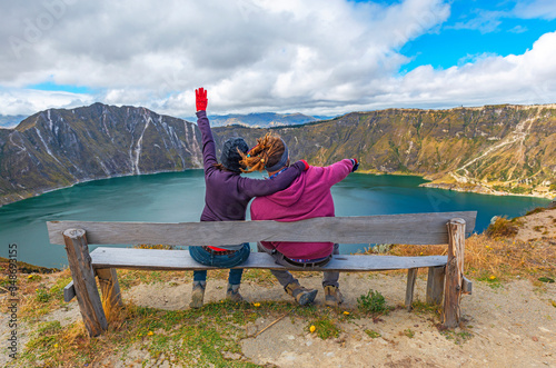 Backpackers enjoying the view of the Quilotoa volcanic crater lake along the Quilotoa Loop hike, south of Quito, Ecuador.