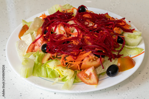 Fresh vegetable salad isolated on white plate