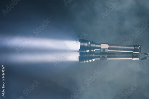 ray of pocket flashlight in smoke, copy-space background