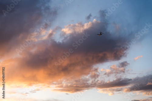 An airplane flying close to the ground during a sunset. 