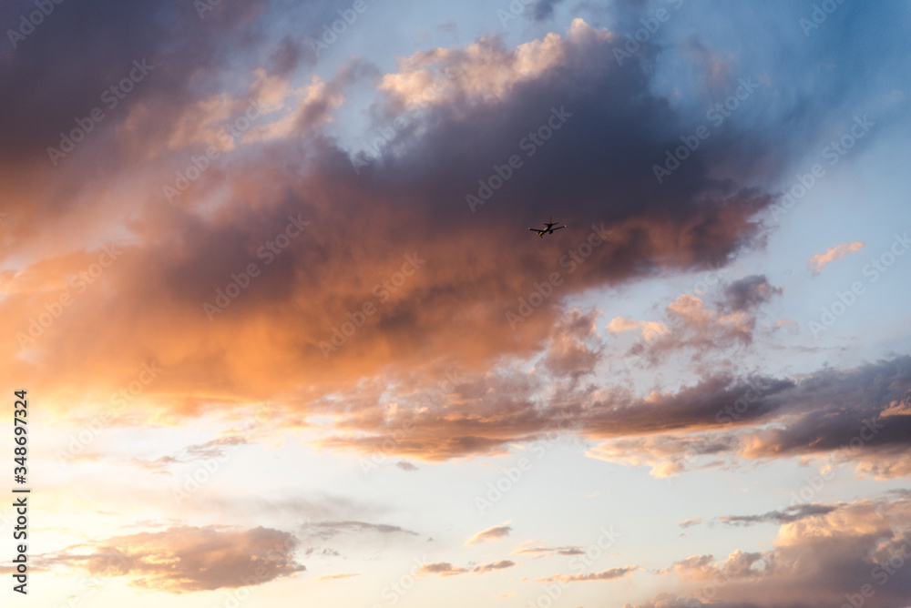 An airplane flying close to the ground during a sunset. 