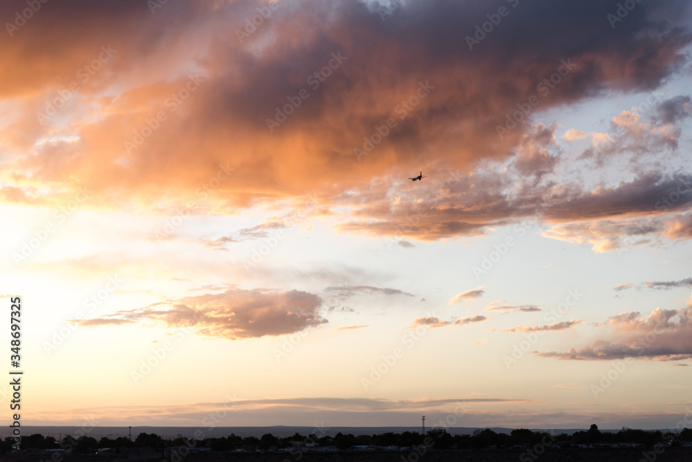 An airplane flying close to the ground during a sunset. 