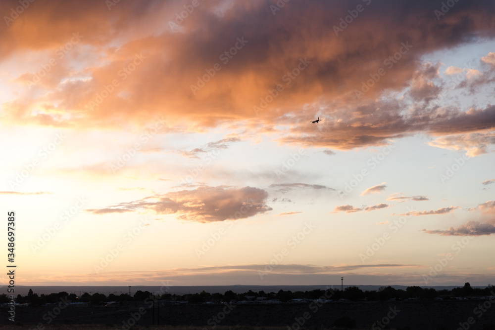 An airplane flying close to the ground during a sunset. An airplane flying close to the ground during a sunset.