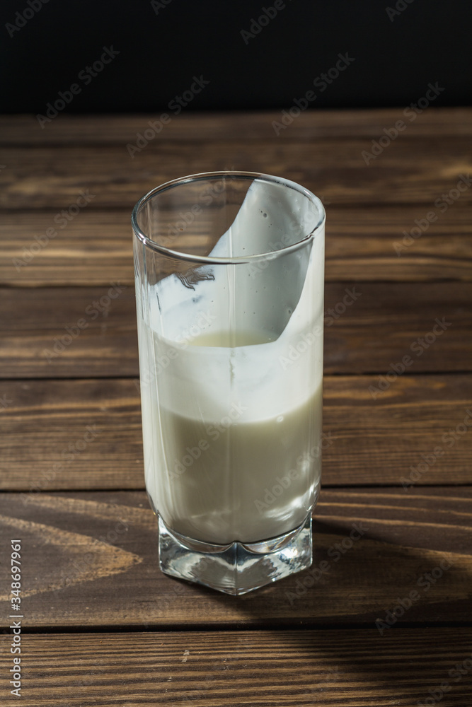 a half full glass of milk is on the table.