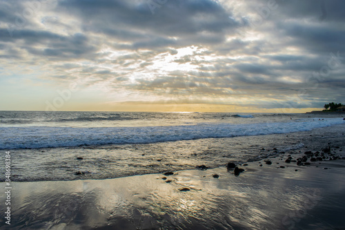 Sunset reflecting on waves and sand on a beach in El Salvador.