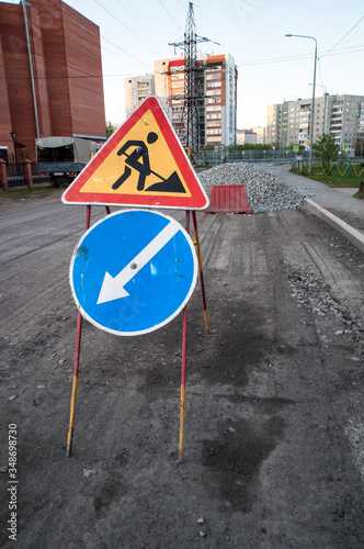 Road repairs, road signs and a bunch of crushed stone on the road.