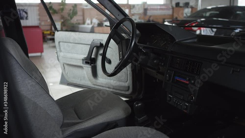 Retro car interior old black saloon, dashboard and steering wheel smooth camera movement close up view inside car