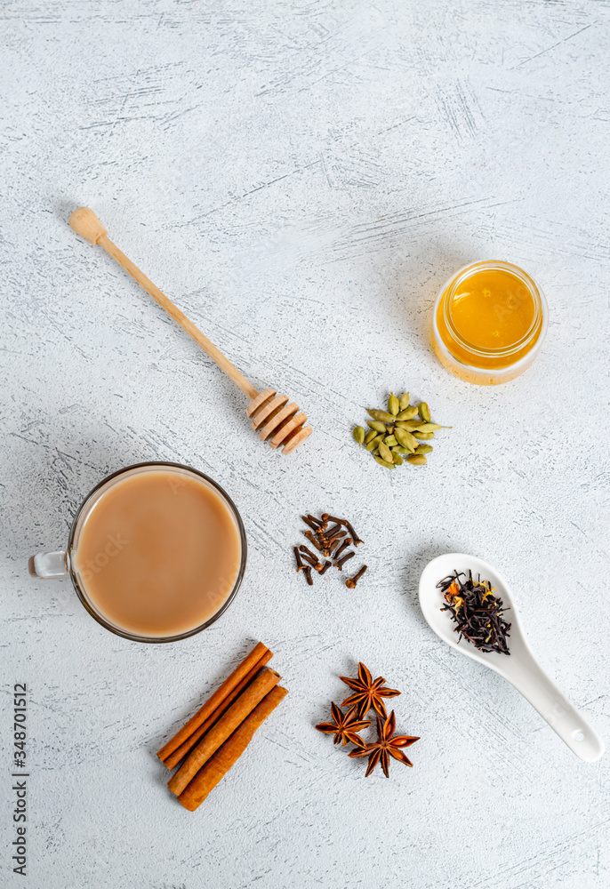 Traditional indian drink masala tea in a glass cup with ingredients for cooking. Traditional indian drink masala tea in a glass cup with ingredients for cooking.