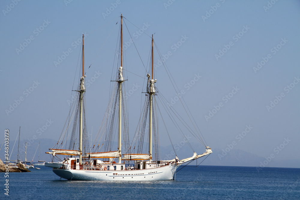 A large white three-masted yacht at sea.