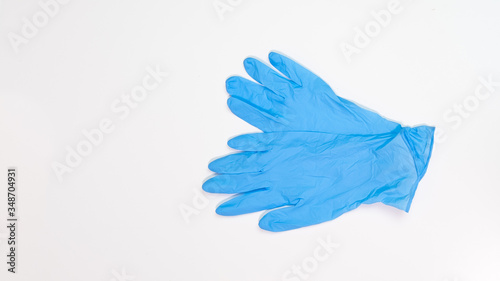 Blue latex medical gloves on white table. Top down with copy space on left.