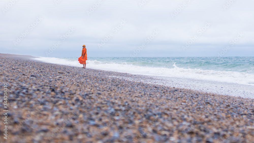Monks walking at the sea.