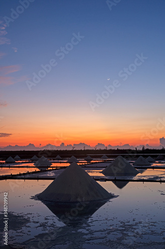 Sea salt evaporation pond with golden sunset sky background in Tainan, Taiwan 