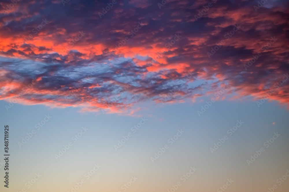 Beautiful sky at sunset. Purple and pink unusual clouds. Blurred background for design.