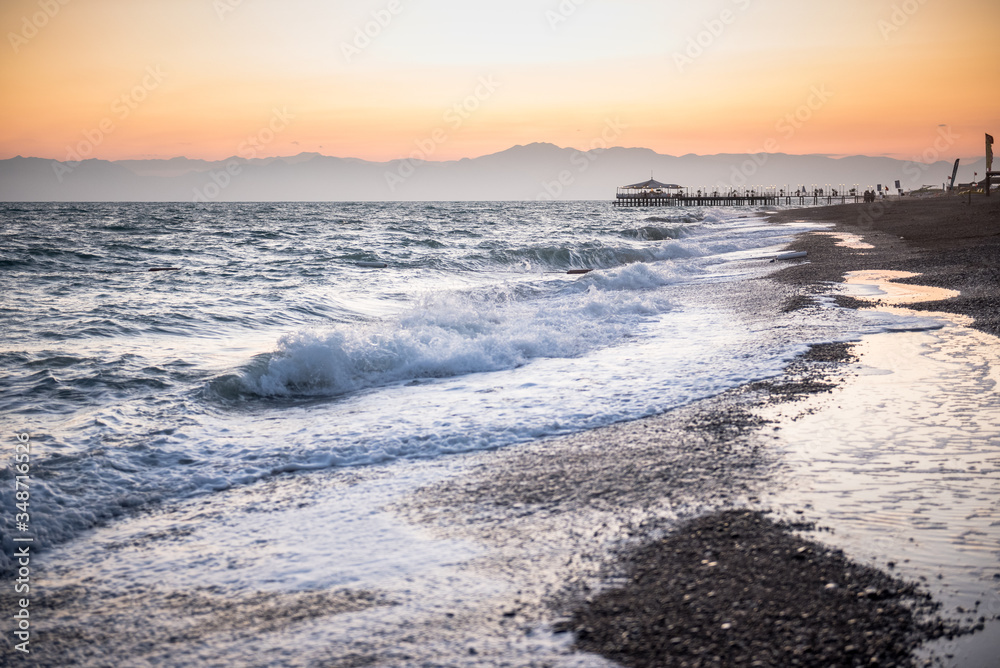 Fototapeta premium Waves from the sea at a beach in sunset