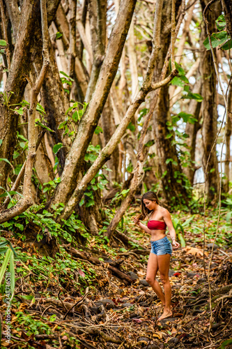 A young girl hiking and walking through a tropical jungle. photo