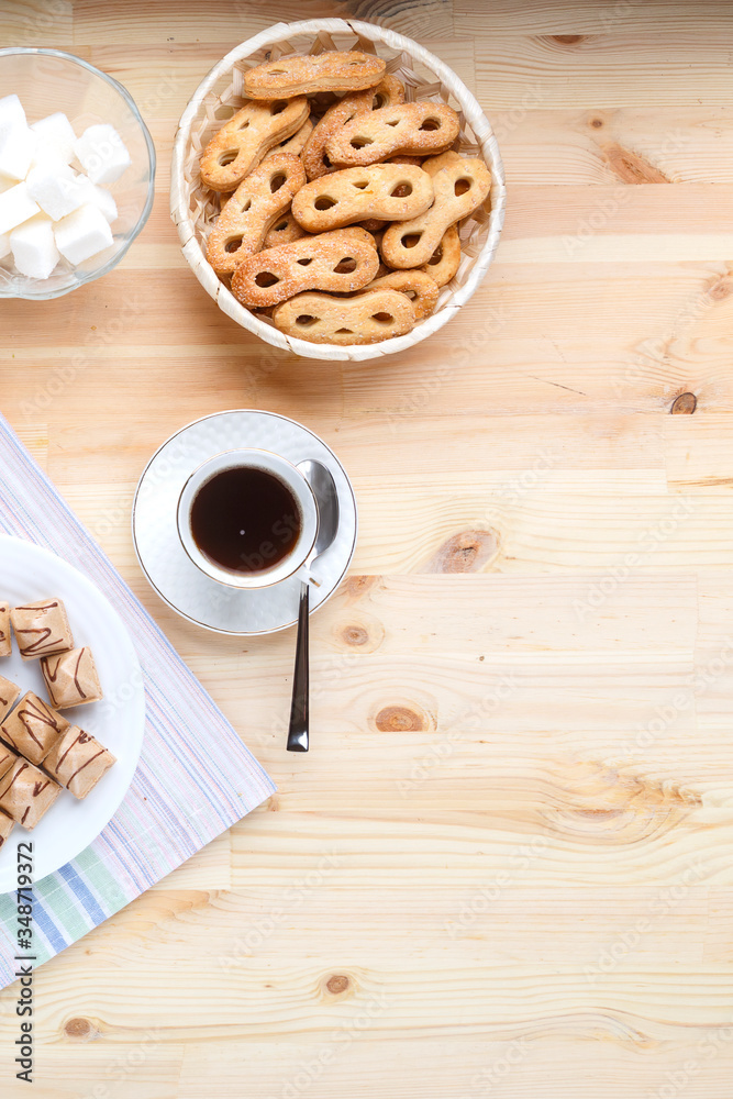 Two cup of coffee on a napkin on a wooden table and sweets with sugar. Copy space. Two cup of coffee on a napkin on a wooden table and sweets with sugar. Copy space.