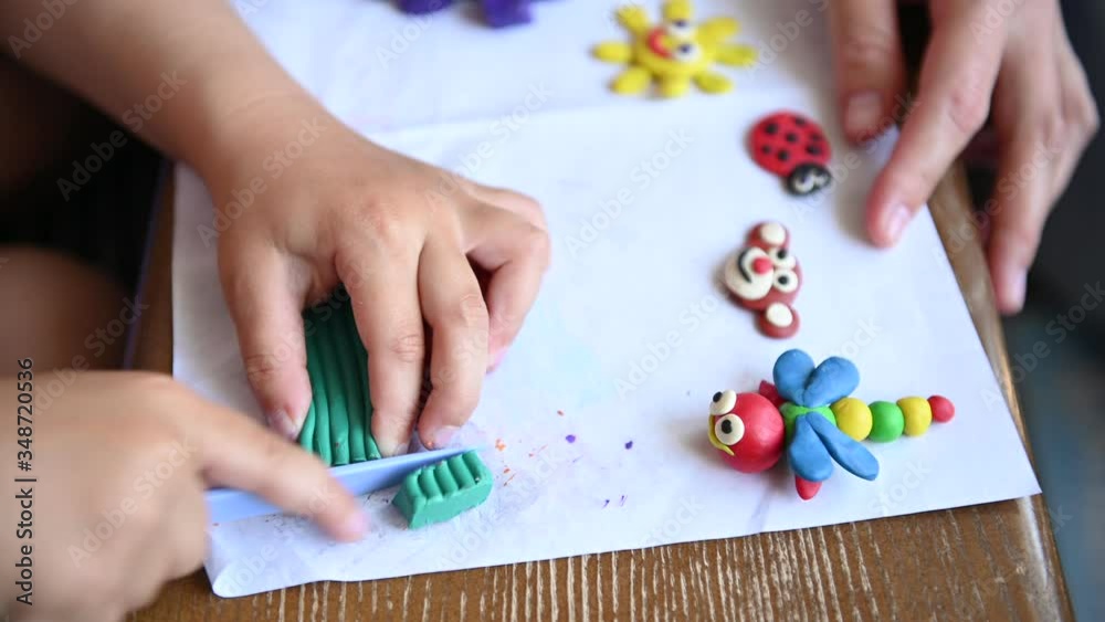 A little boy plays plasticine. He makes various small sculptures. A little boy plays plasticine. He makes various small sculptures.