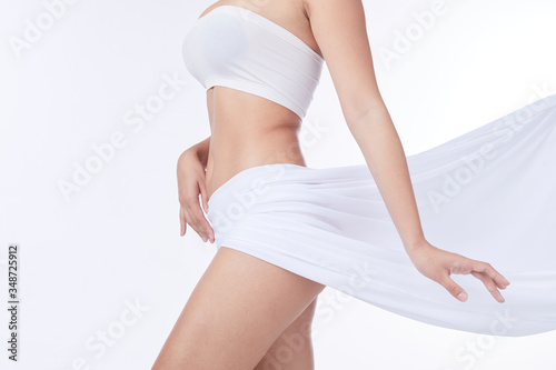Slim tanned woman Perfect Body . Slim toned young body of the girl . An example for sports and fitness or plastic surgery and aesthetic cosmetology.