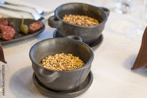 Two stone bowls with fresh and yellow wheat grain