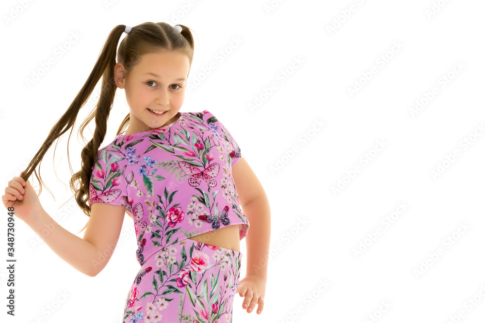 A little girl fixes her hair.The concept of style and fashion, h A little girl fixes her hair.The concept of style and fashion, h