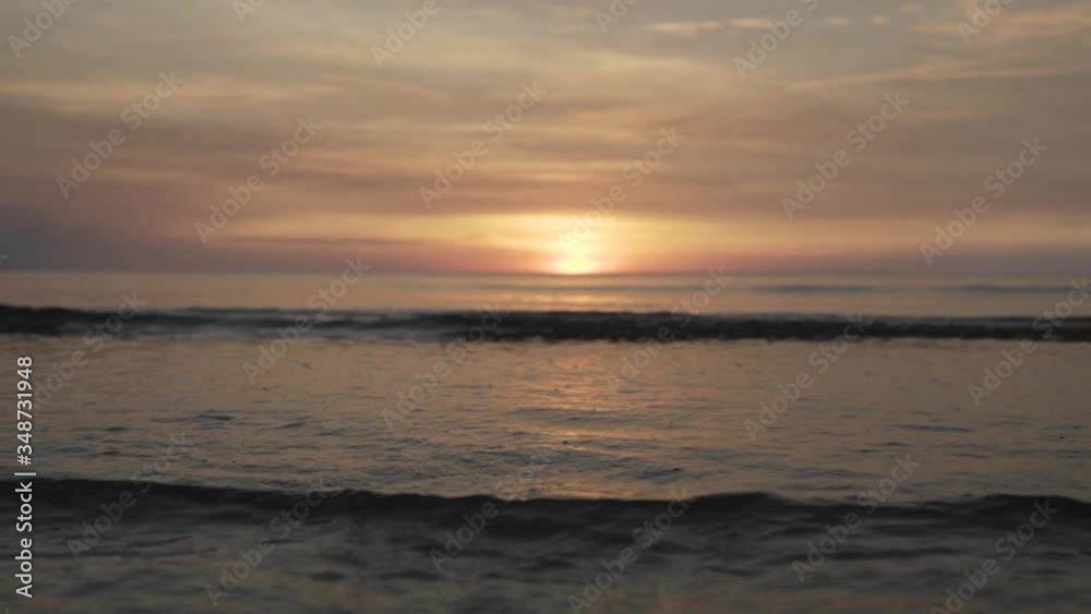 Small waves reaching the beach in slow motion with a beautiful sunset in the horizon. Small waves reaching the beach in slow motion with a beautiful sunset in the horizon.