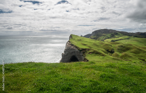 Coastal landscape with green rolling hills and cliffs, shot at Cape Farewell, New Zealand