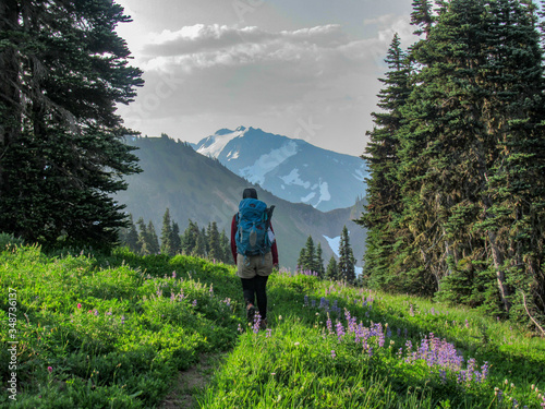 Woman hiking with mountains and flowers photo