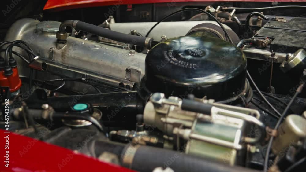 Start of a red Old-Timer car. Close shot of a old engine starting. Red Mercedes SL cabriolet in the woods on a sunny day. Start of a red Old-Timer car. Close shot of a old engine starting. Red Mercedes SL cabriolet in the woods on a sunny day.