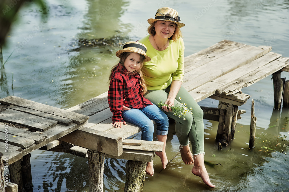 Happy mother and daughter in the countryside by the river . Happy mother and daughter in the countryside by the river .