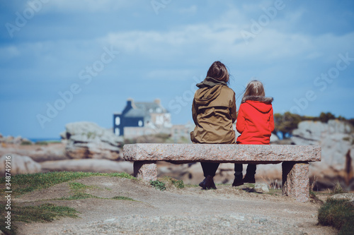 the sisters are sitting on the shore of the ocean