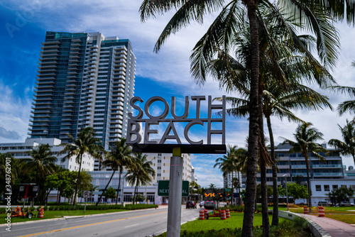South Beach Miami Street Sign. A street sign marking South Beach, Miami. With palm tree against the background of a street with a skyscraper. Florida, US. © Tverdokhlib