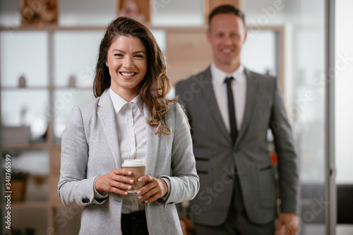 Portrait of beautiful businesswoman in office. Young businesswoman drinking coffee.