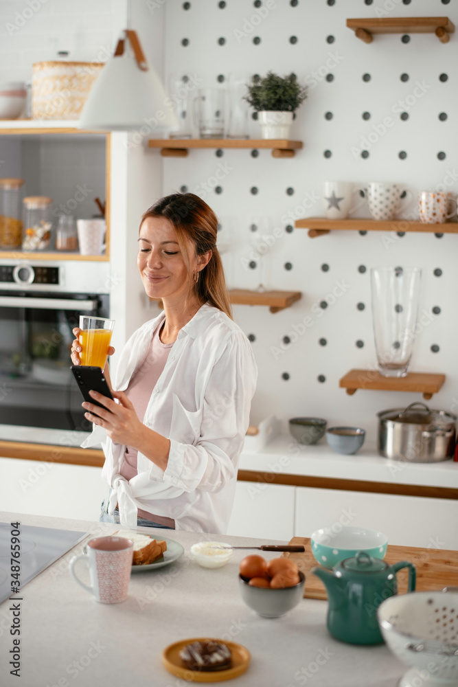 Young woman in kitchen. Beautiful woman preparing breakfast and drinking juice. Young woman in kitchen. Beautiful woman preparing breakfast and drinking juice.