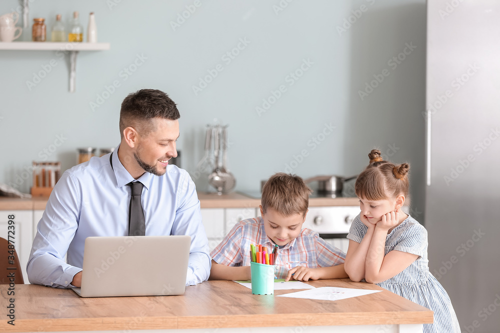 Obraz premium Working father with little children at home