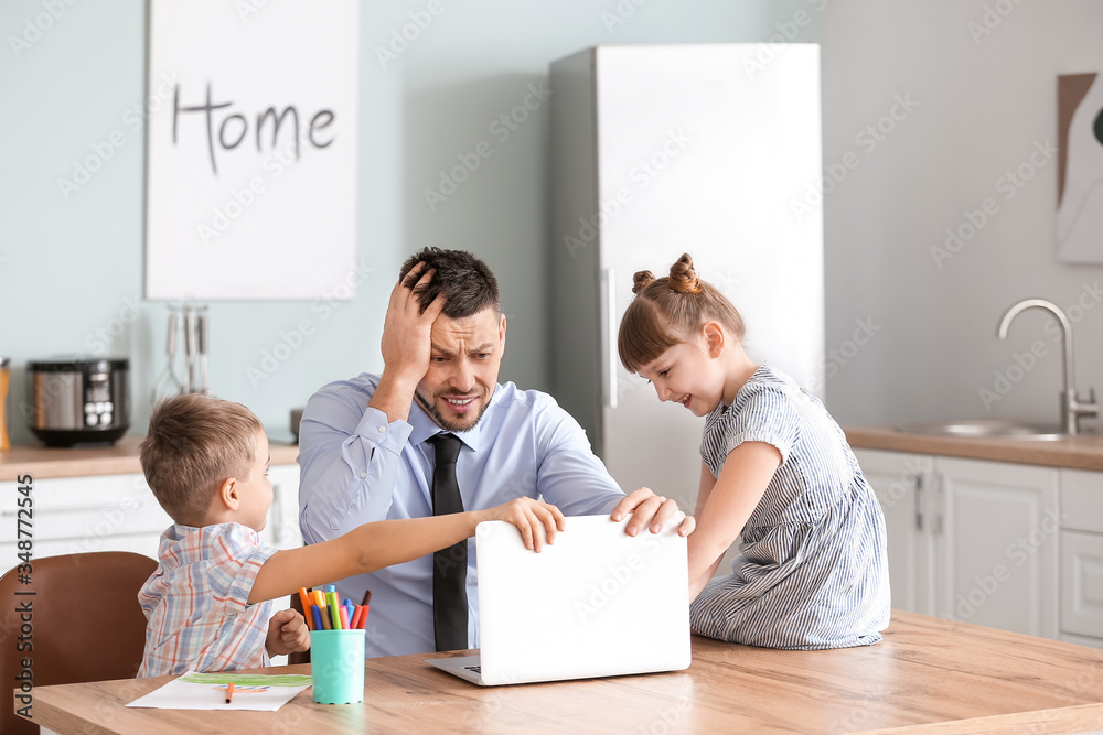 Little children keeping father from his work at home Little children keeping father from his work at home