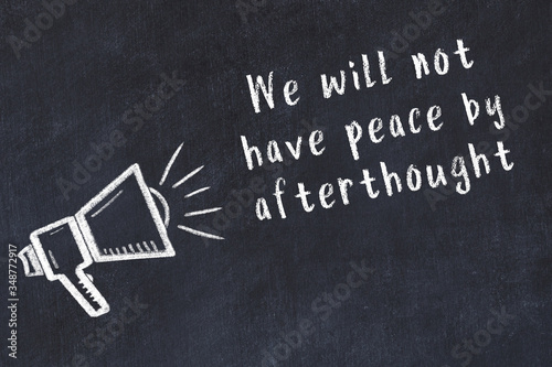 Chalk loudspeaker and wise quote on black desk