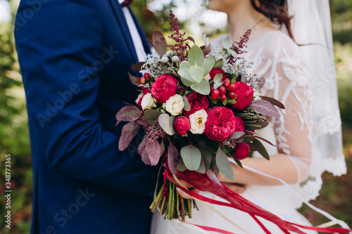 Beautiful wedding bouquet. Delicate petals of white and red roses.